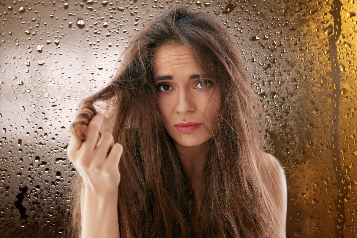 Frizzy hair with water droplets in the background symbolizing high summer humidity